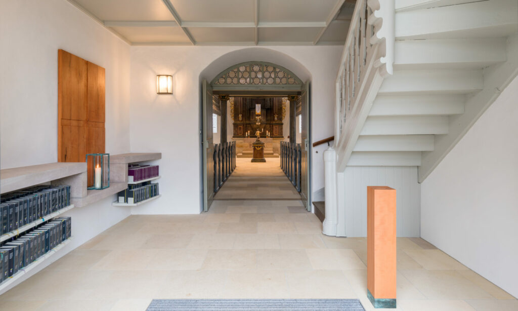Moderner Eingangsbereich mit Treppe und Regal im Hintergrund