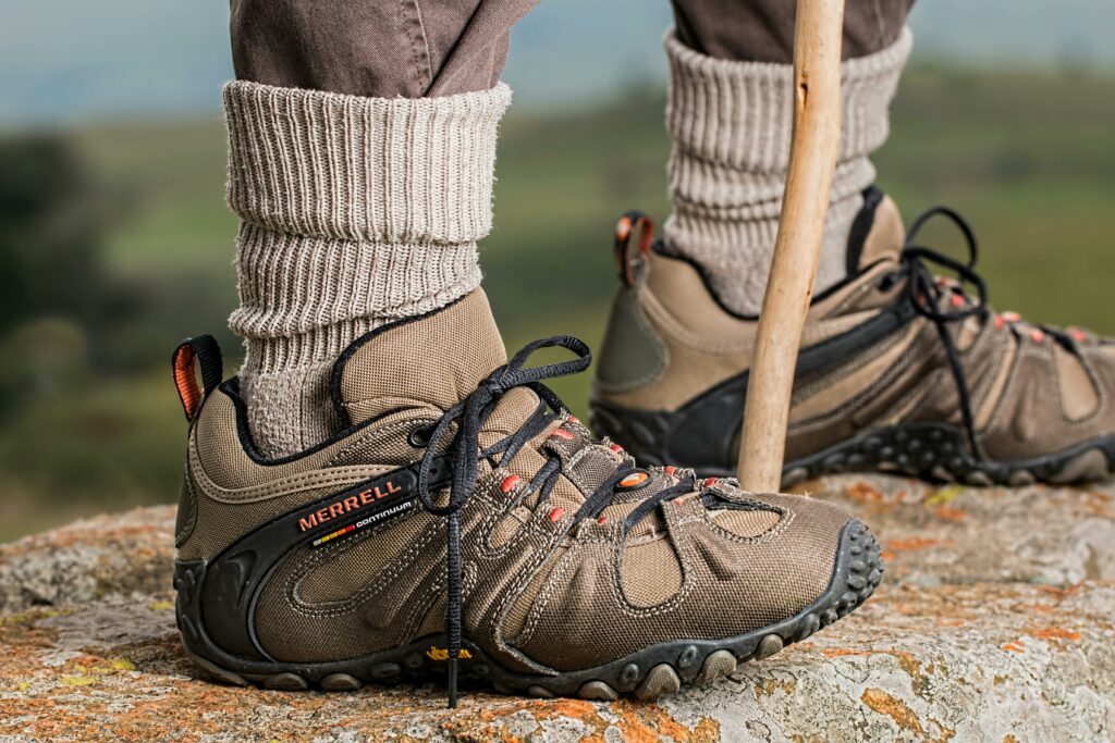 Wanderer mit Stiefeln und Wanderstock auf Felsen