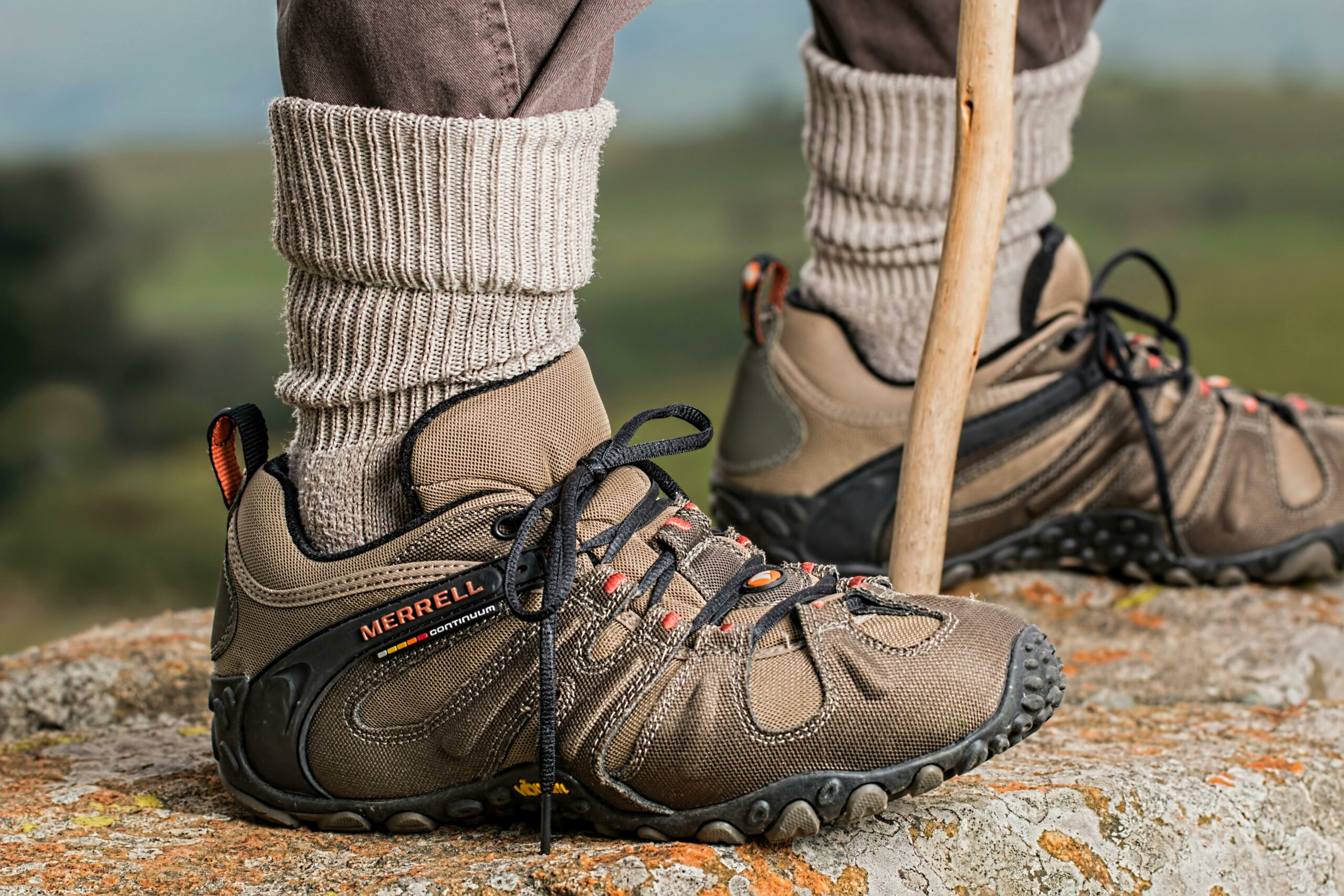 Wanderer mit Stiefeln und Wanderstock auf Felsen