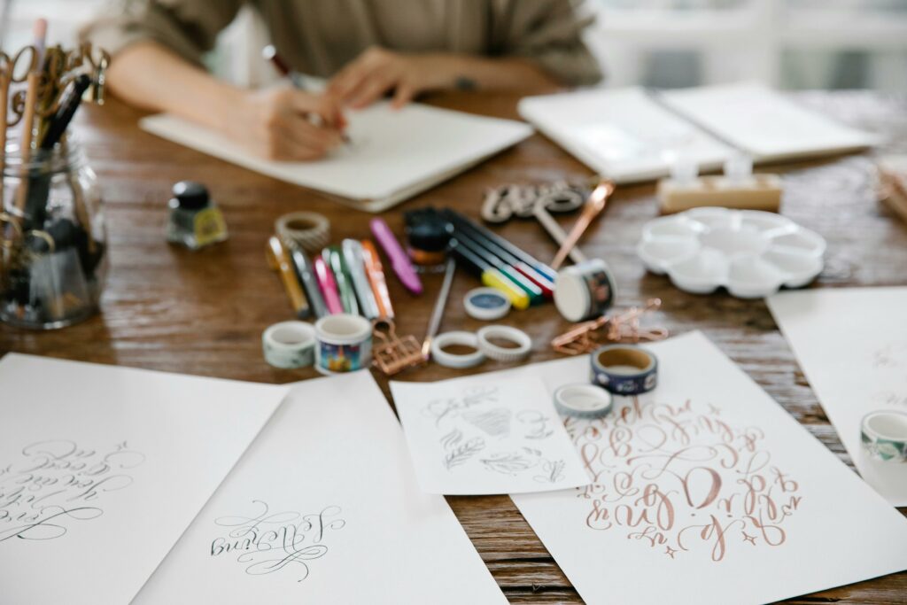 Künstlerisches Handlettering mit Stiften und Tinte auf Tisch